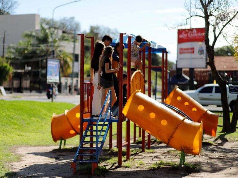 Niños, niñas y adolescentes jugando en una plaza.