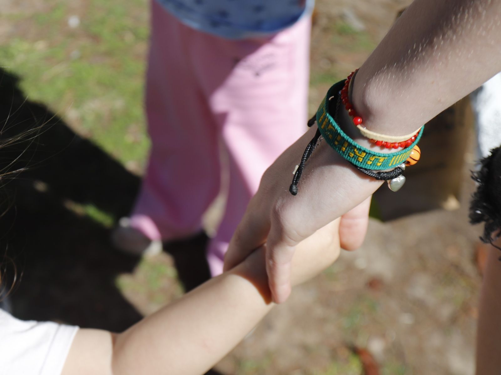 Foto de la mano de un niño entrelazada con la de una persona joven